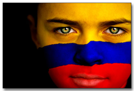 Portrait of a boy with the flag of Colombia painted on his face.